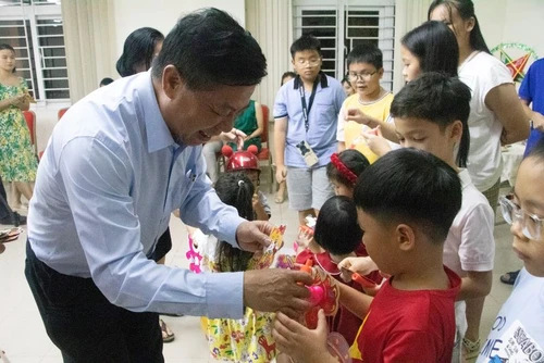 Đại sứ Nguyễn Huy Tăng tặng quà cho các cháu thiếu nhi. (Ảnh: Nguyễn Hiệp)