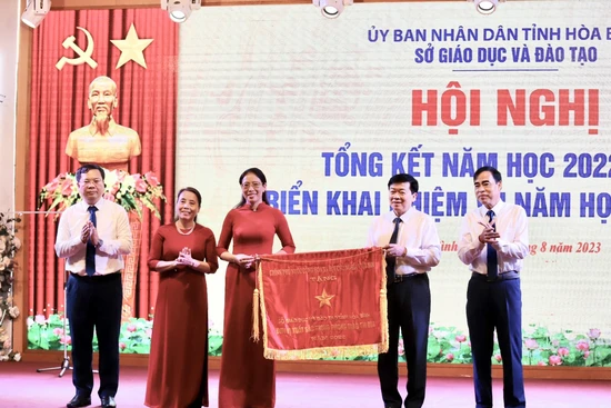 Đồng chí Nguyễn Văn Chương, Phó Chủ tịch Ủy ban nhân dân tỉnh Hòa Bình (thứ 2 từ trái sang) trao cờ thi đua của Thủ tướng Chính phủ cho ngành Giáo dục và Đào tạo tỉnh.