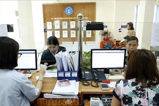 Giải quyết thủ tục hành chính tại bảo hiểm xã hội địa phương. (Ảnh: TTXVN)