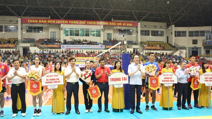 Đại diện Ban Tổ chức trao cờ lưu niệm cho các đội bóng tham gia giải bóng chuyền Cúp Hùng Vương.