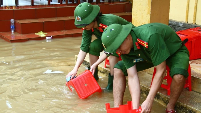 Đoàn viên thanh niên Công an tỉnh Quảng Bình giúp trường học vùng lũ vệ sinh trường lớp, lau rửa bàn ghế.