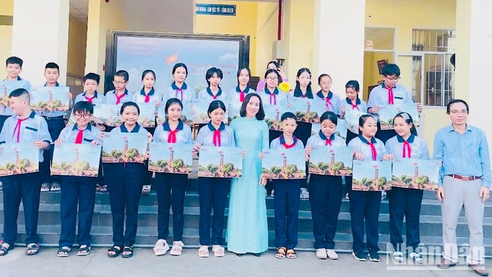 Nhà báo Trọng Duy, Trưởng Văn phòng đại diện Báo Nhân Dân tại Bạc Liêu và cô Trần Kim Thi, Bí thư Chi bộ, Hiệu trưởng Trường trung học cơ sở Lê Thị Cẩm Lệ (thành phố Bạc Liêu) trao tặng phụ san đặc biệt Cột cờ Hà Nội cho các em học sinh.