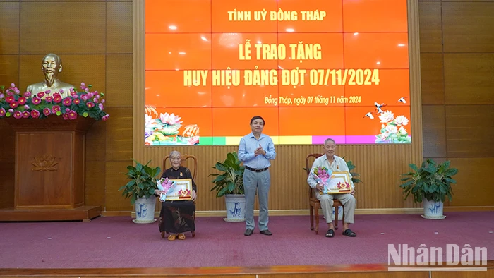 Phó Bí thư Thường trực Tỉnh ủy Đồng Tháp Phan Văn Thắng trao Huy hiệu 65 năm tuổi Đảng. (Ảnh: HỮU NGHĨA)