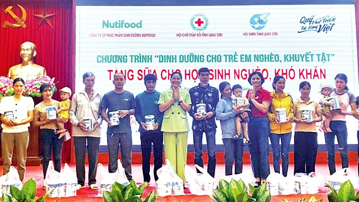 Lãnh đạo Hội Chữ thập đỏ tỉnh Lạng Sơn và huyện Lộc Bình trao sữa cho đại diện gia đình có trẻ em nghèo. (Ảnh Hà Trang)