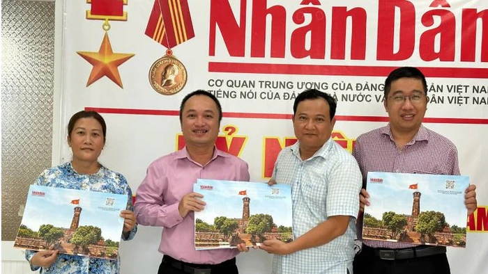 Văn phòng đại diện Báo nhân Dân tại tỉnh Bến Tre bàn giao tờ phụ san về Cột cờ Hà Nội cho Thư viện Nguyễn Đình Chiểu. (Ảnh: HOÀNG TRUNG)