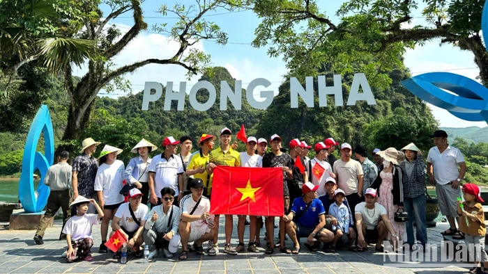 Du khách chụp ảnh lưu niệm trước khi xuống thuyền tham quan động Phong Nha và động Tiên Sơn.