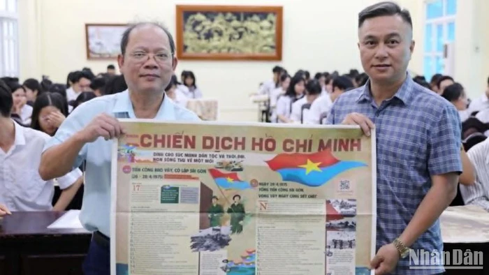 Nhà báo Mai Tú, Trưởng Văn phòng đại diện Báo Nhân Dân tại tỉnh Thái Bình (bên phải) trao tặng thầy và trò Trường trung học phổ thông chuyên Thái Bình ấn phẩm đặc biệt kỷ niệm 50 năm Giải phóng miền nam, thống nhất đất nước.