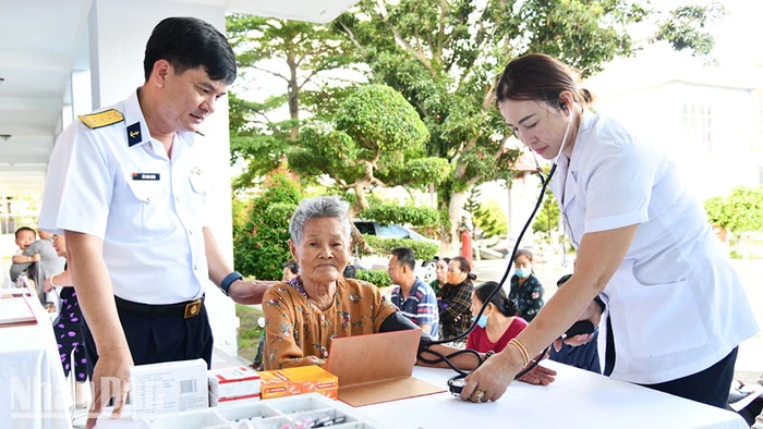 Chỉ huy Phòng Hậu cần-Kỹ thuật thăm hỏi người dân đến khám bệnh.