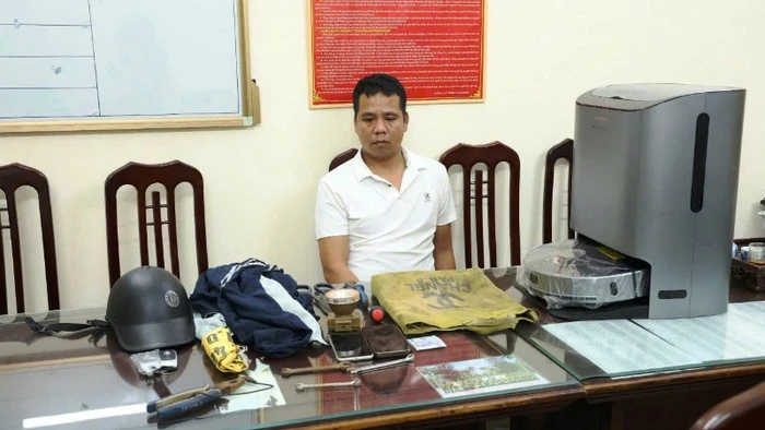 Đối tượng Hoàng Hà Trung cùng một số tang vật tại cơ quan Công an tỉnh Nam Định. (Ảnh: Công an Nam Định)