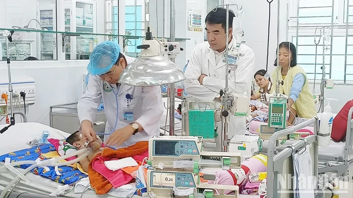 Bác sĩ Phạm Văn Dũng (bên trái) thăm khám cho bệnh nhân.
