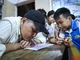 Người thầy viết chữ bằng miệng Phùng Văn Trường dạy cho các em học sinh trong làng. (Ảnh: THÀNH ĐẠT)