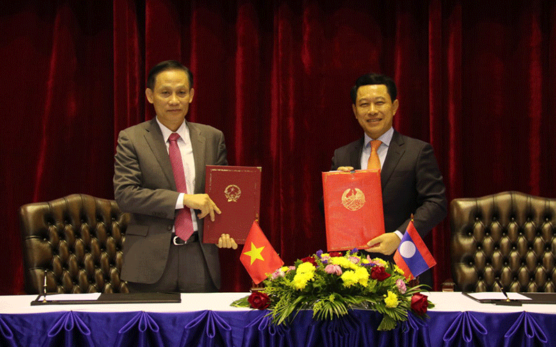 Thứ trưởng Ngoại giao Lê Hoài Trung (trái) trao Biên bản cuộc họp cho Bộ trưởng Ngoại giao Lào Saleumxay Kommasith.