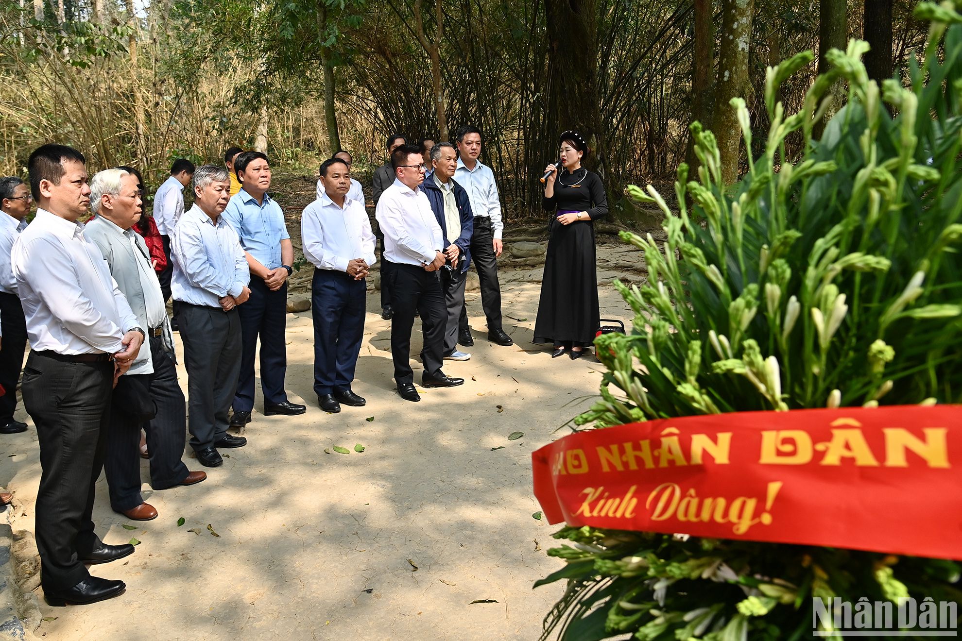 Đoàn đại biểu Báo Nhân Dân nghe giới thiệu, thuyết minh tại lán Nà Nưa thuộc Khu di tích quốc gia đặc biệt Tân Trào.