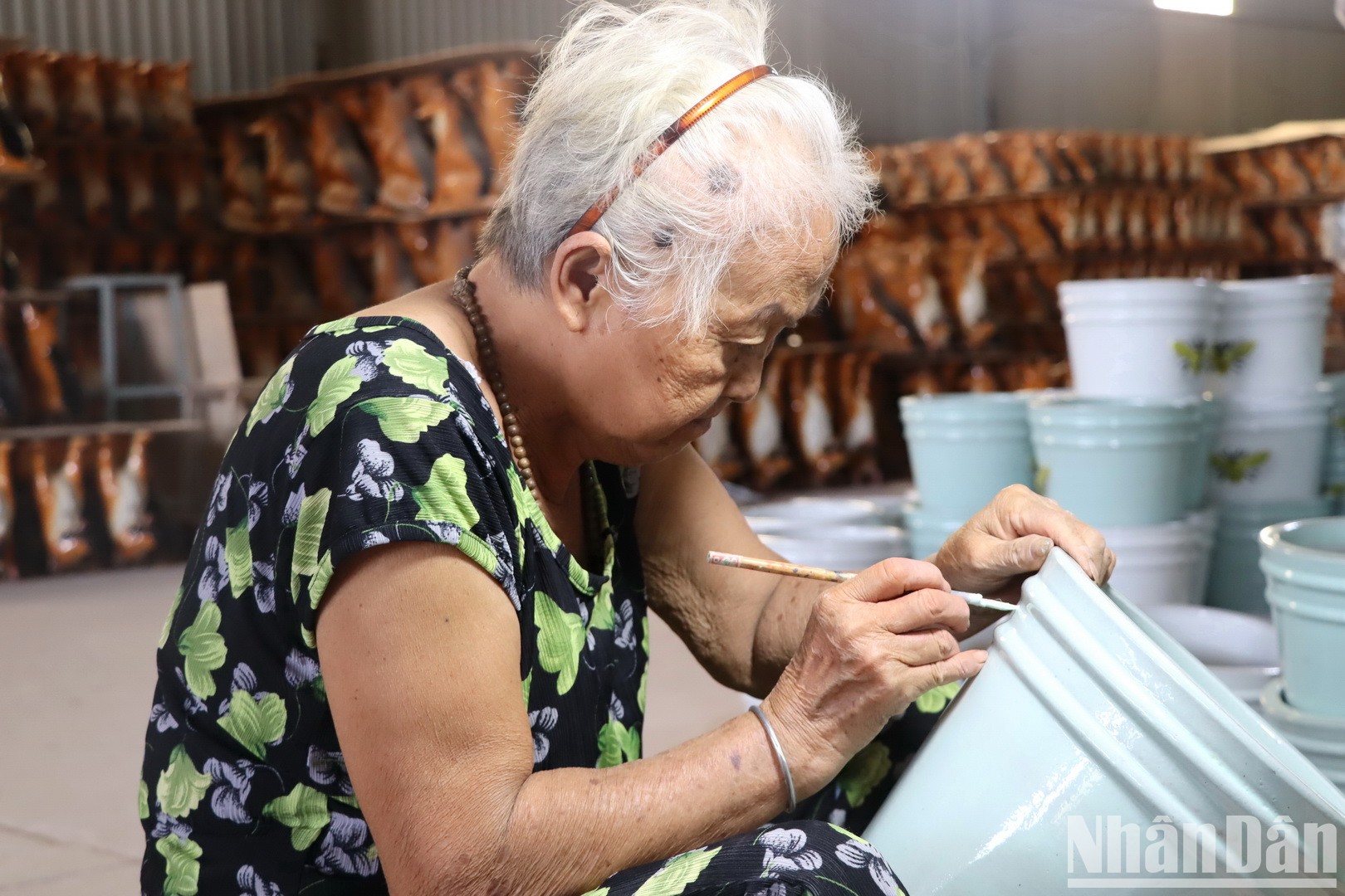 Một người thợ cao tuổi khắc hoa văn lên sản phẩm gốm Biên Hòa.