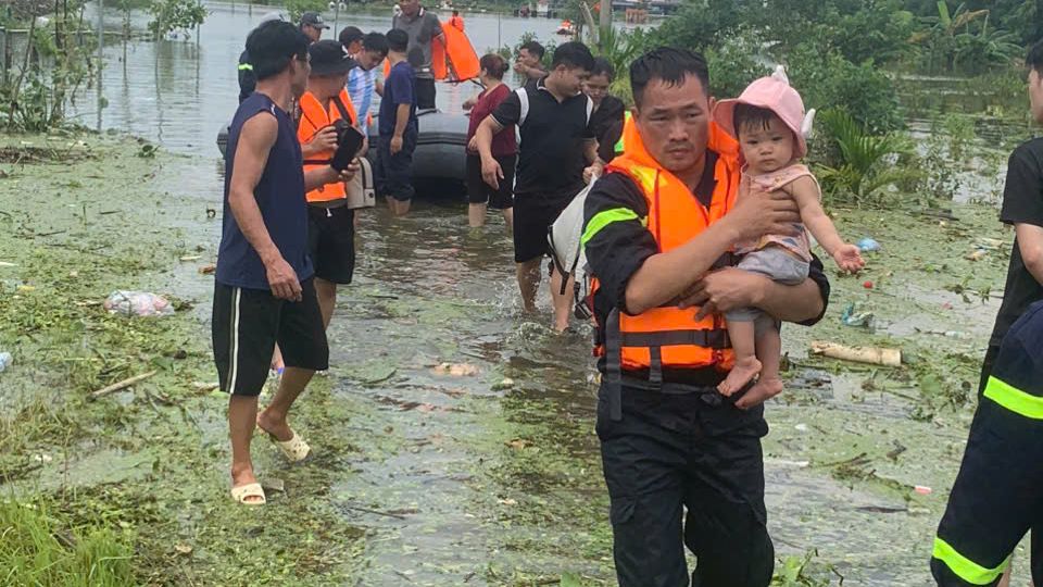 Cảnh sát PCCC trên sông bế em bé di dời về nơi an toàn. 