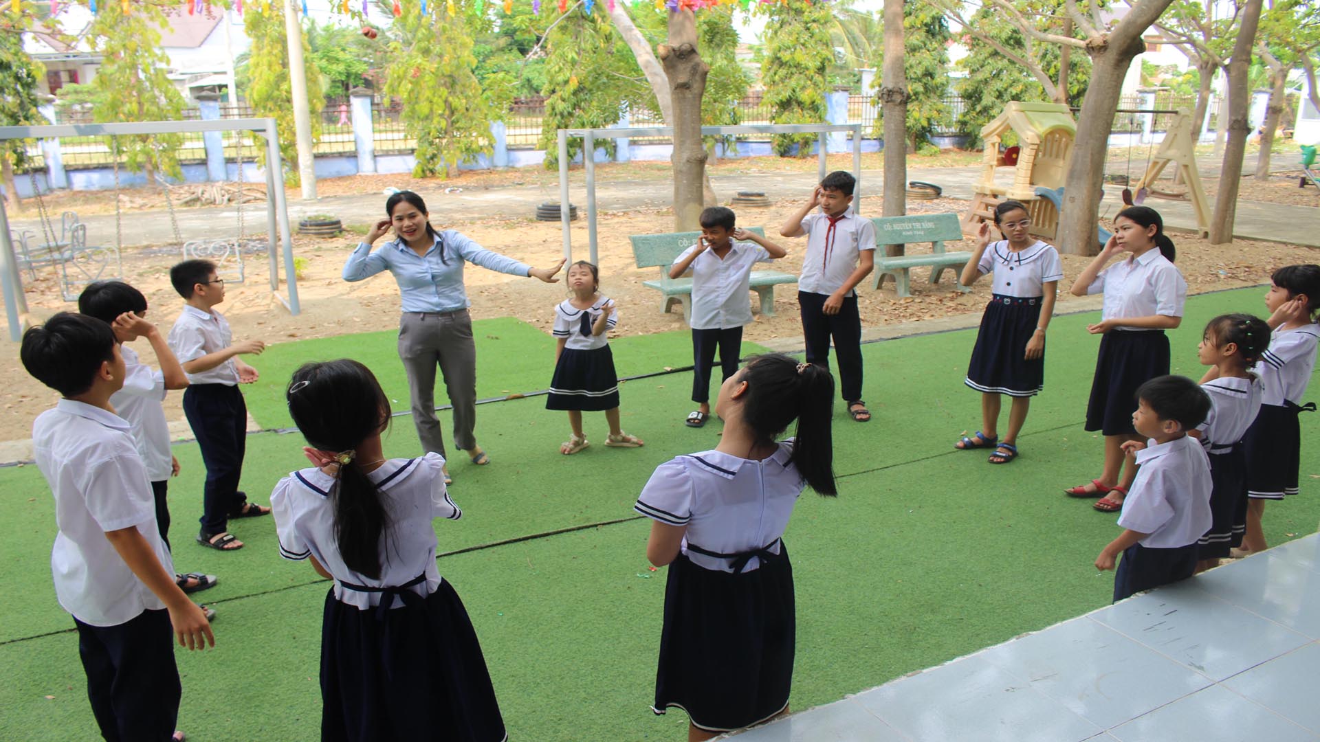 Cô giáo Nguyễn Thị Năng giảng dạy cách thể hiện ngôn ngữ bằng các ký hiệu tạo hình từ hai bàn tay cho học sinh bị khiếm thính tại Trung tâm Hỗ trợ phát triển giáo dục hòa nhập tỉnh Ninh Thuận.