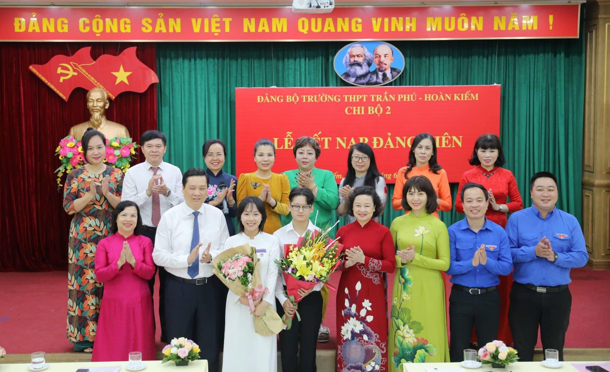 Các đại biểu Thành ủy Hà Nội, Quận uỷ Hoàn Kiếm chúc mừng hai đảng viên trẻ là học sinh lớp 12 của Trường Trần Phú-Hoàn Kiếm. (Ảnh: Thế Đại.)