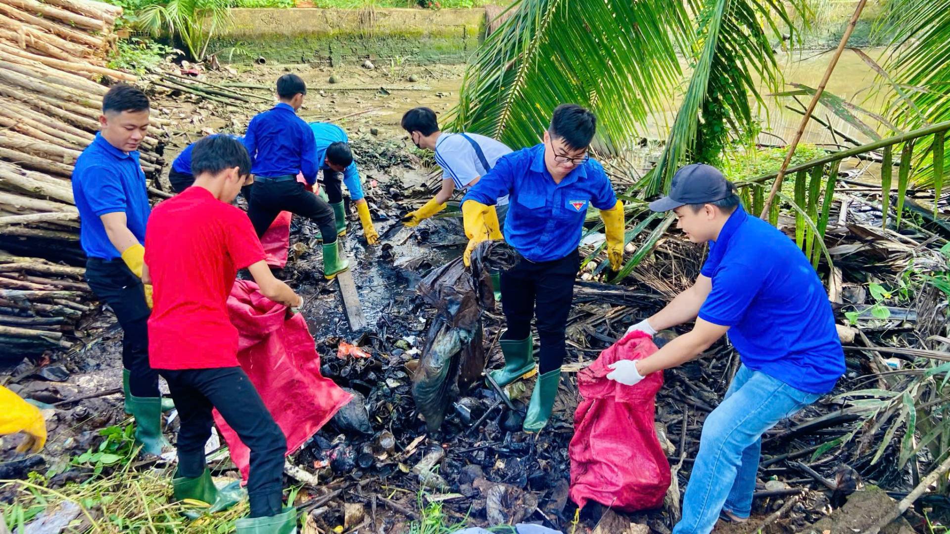 Lực lượng đoàn viên, thanh niên huyện Mỏ Cày Nam tích cực dọn dẹp vệ sinh môi trường. (Ảnh: HOÀNG TRUNG)