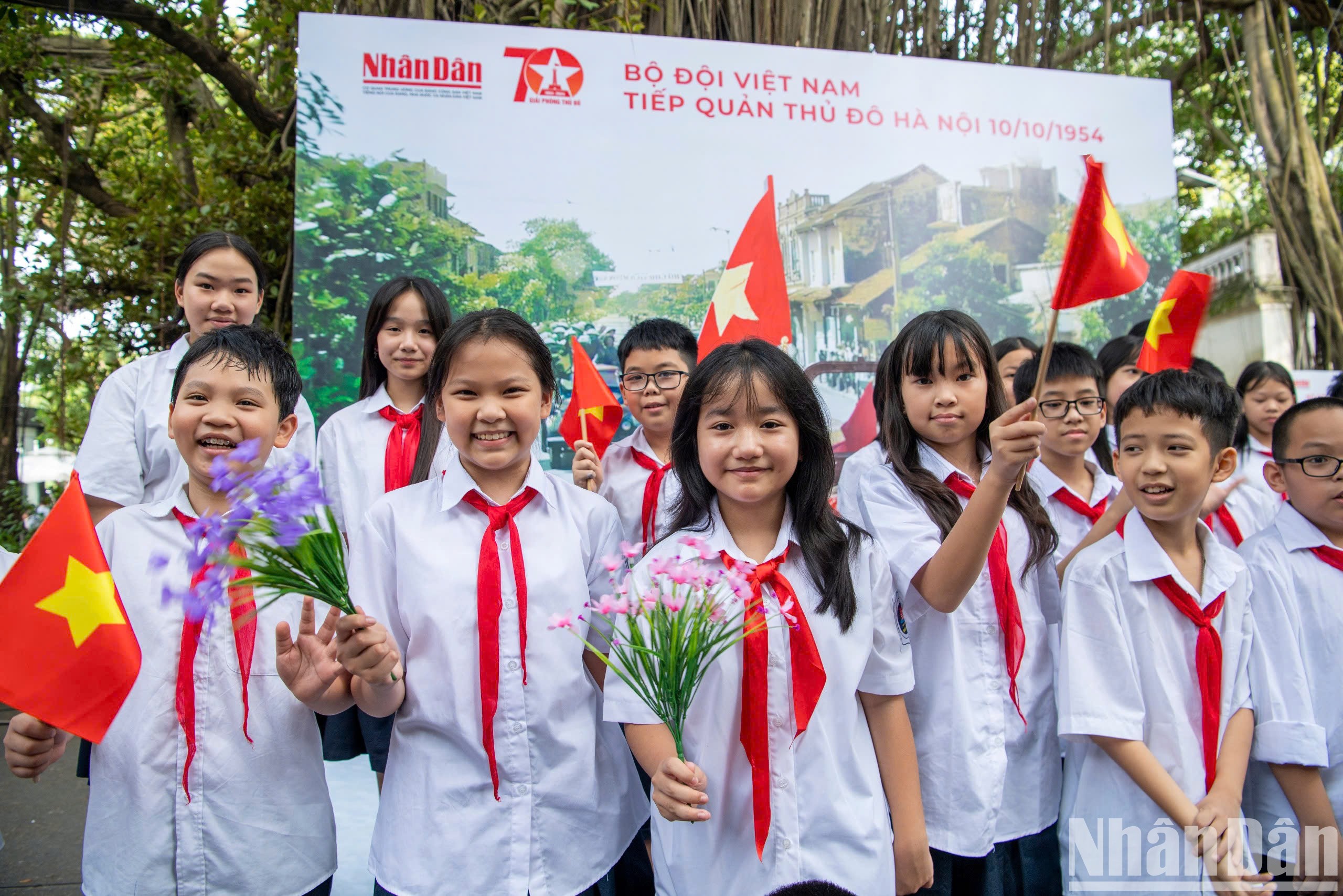 Các em học sinh Trường trung học cơ sở Hoàn Kiếm thích thú với cờ hoa tại sự kiện. 