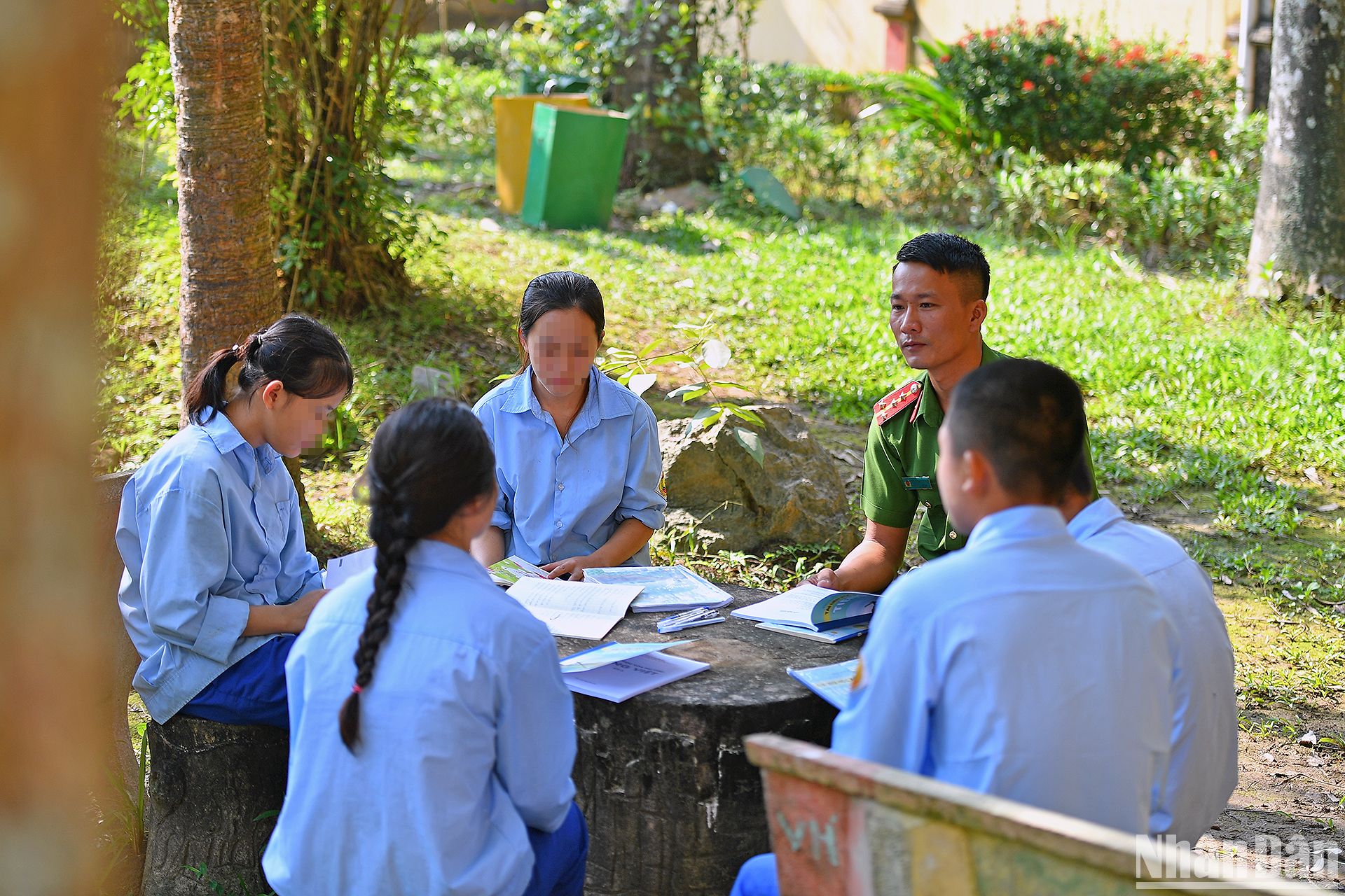 Đại úy Trần Đại Lượng ôn lại bài tập cùng học sinh trong khuôn viên trường.