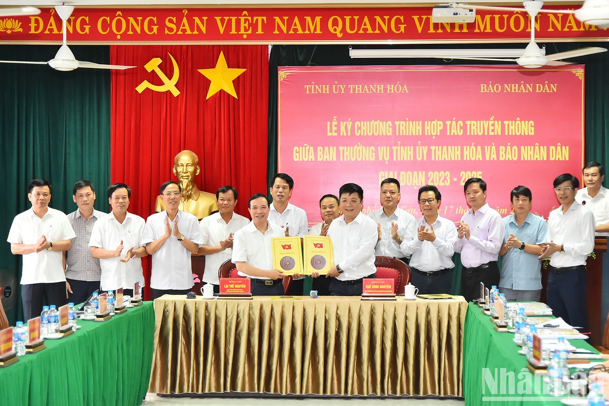 Phó Tổng Biên tập Báo Nhân Dân Quế Đình Nguyên và Phó Bí thư Thường trực Tỉnh ủy Thanh Hoá Lại Thế Nguyên trao nhau bản thỏa thuận hợp tác truyền thông giữa 2 cơ quan trước sự chứng kiến của lãnh đạo 2 đơn vị.