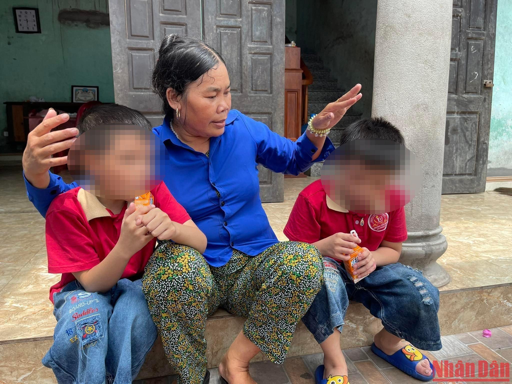 Bà Cúc và 2 người con không chung huyết thống Bảo Q., Bảo K. bên hiên nhà. 