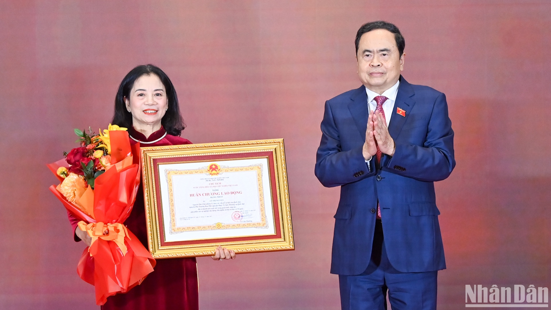 Chủ tịch Quốc hội Trần Thanh Mẫn trao Huân chương Lao động hạng Nhất và tặng hoa chúc mừng đồng chí Lê Thị Nguyệt.