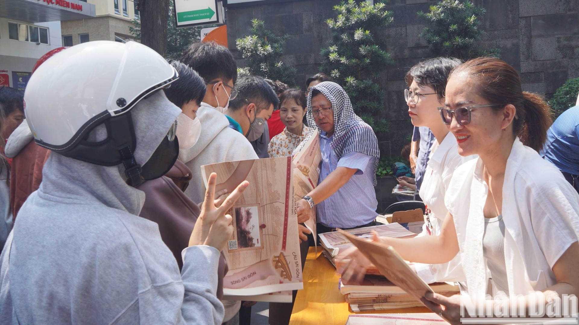 Lãnh đạo, phóng viên Cơ quan đại diện Báo Nhân Dân tại khu vực miền nam trao phụ san đặc biệt cho bạn đọc.