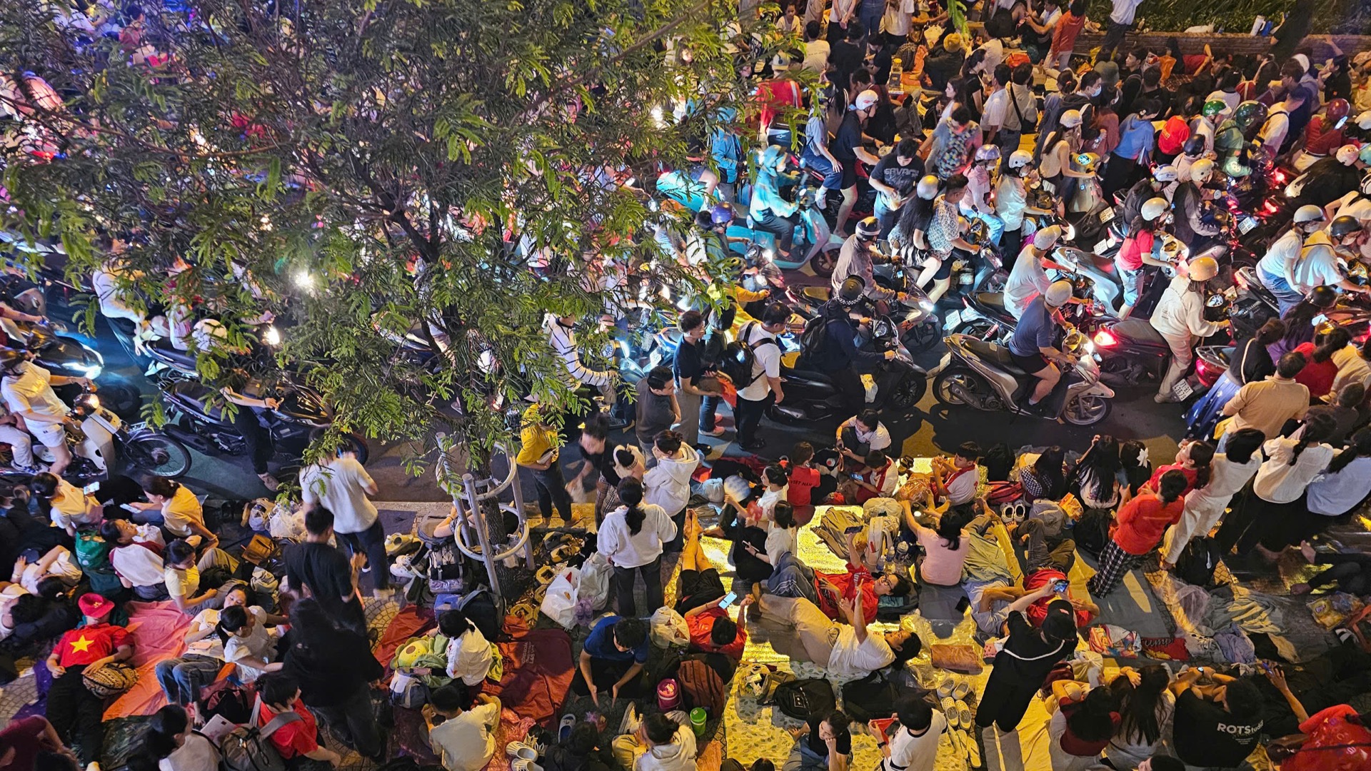 Các vỉa hè ở các trục đường các khối diễu binh đi qua đều kín người ngồi. (Ảnh: HẢI AN)