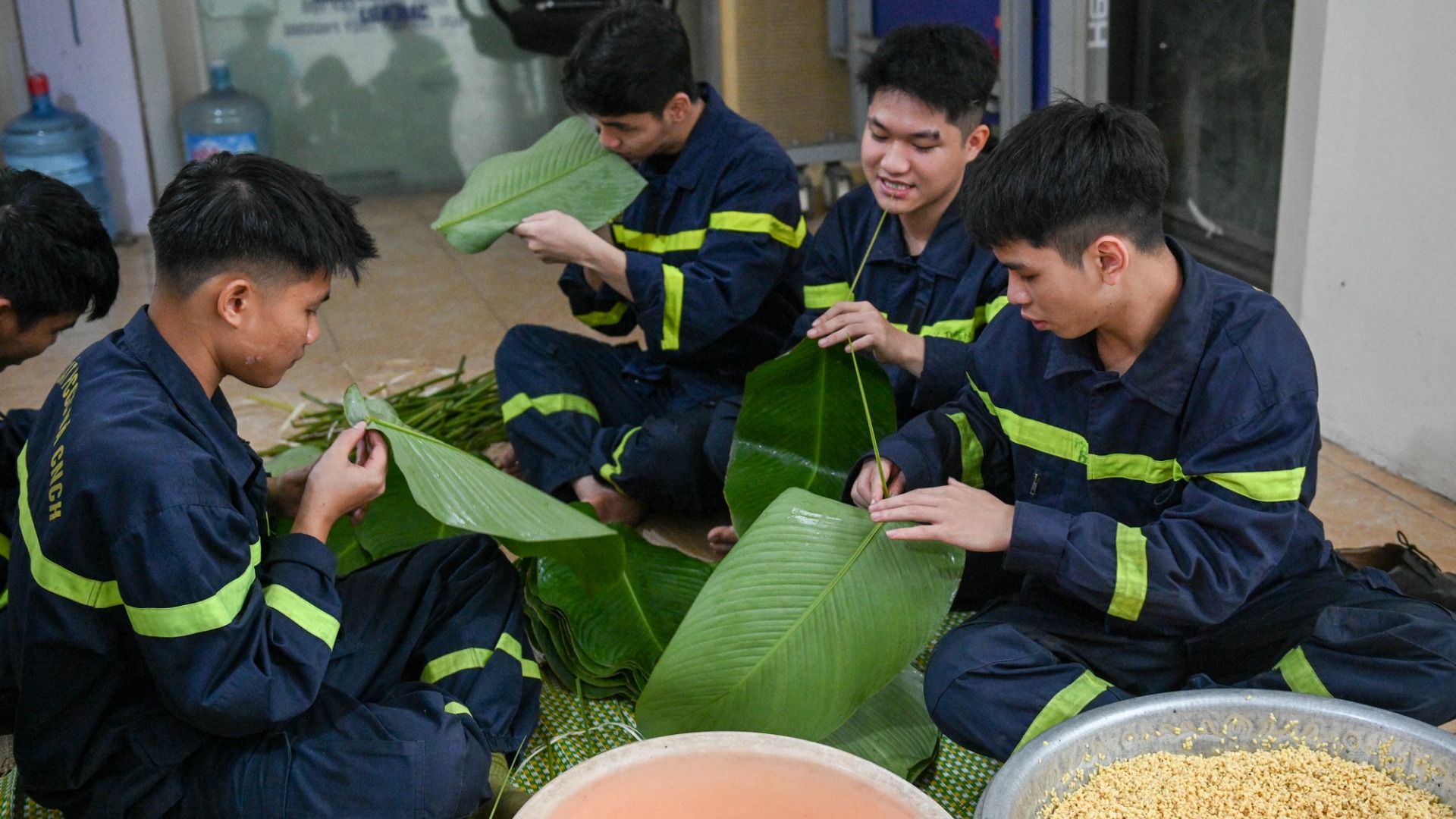 Các chiến sĩ trẻ đội Phòng cháy chữa cháy và Cứu nạn cứu hộ, Công an quận Bắc Từ Liêm cùng nhau gói bánh chưng.