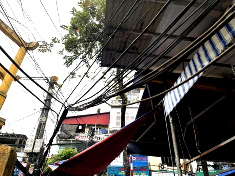 Dây điện sà xuống đường gây nguy hiểm cho người dân -0