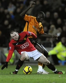 Tiền đạo Rooney của độ M.U nỗ lực tranh bóng với các cầu thủ đội Hull City.