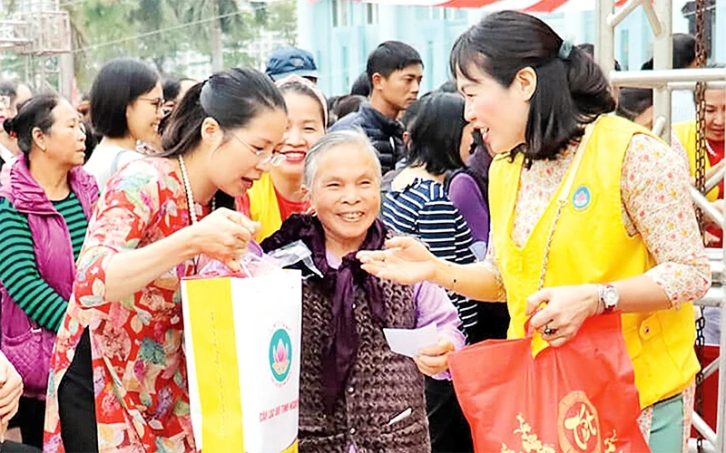 Ðại diện Câu lạc bộ Tình Người trao quà Tết tặng bà con nghèo, người có công trên địa bàn TP Hà Nội trong chương trình Chợ Tết 0 đồng diễn ra tại Nhà văn hóa quận Thanh Xuân. Ảnh: Minh Tâm