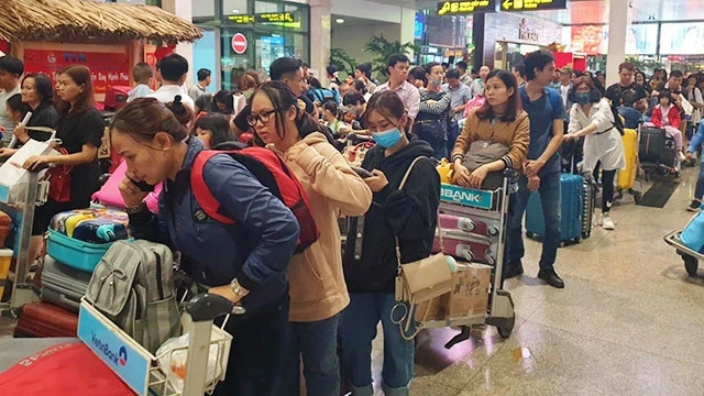 Hành khách xếp hàng dài tại Sân bay Tân Sơn Nhất để làm thủ tục đi máy bay về quê ăn Tết.