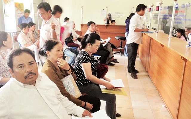 Người dân làm thủ tục cấp giấy chứng nhận quyền sử dụng đất ở và sở hữu nhà ở tại UBND huyện Bình Chánh.
