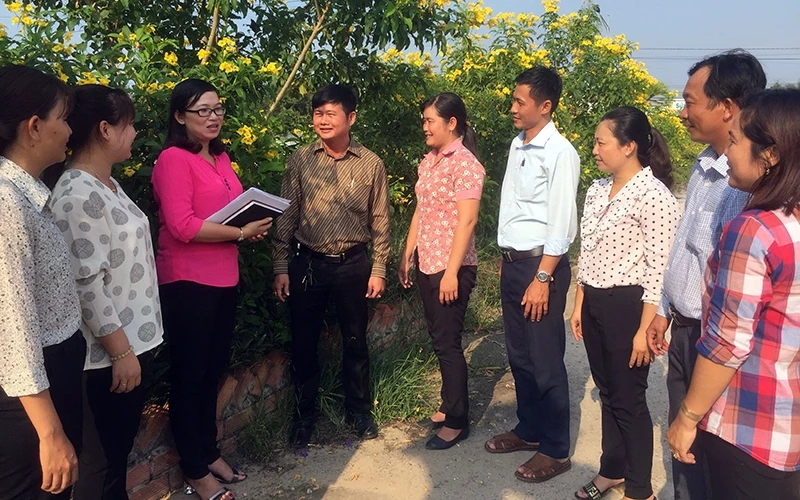 Bí thư Ðảng ủy xã Bình Hiệp Bùi Thùy Trang (người đeo kính) trao đổi cùng người dân về công tác xây dựng nông thôn mới.