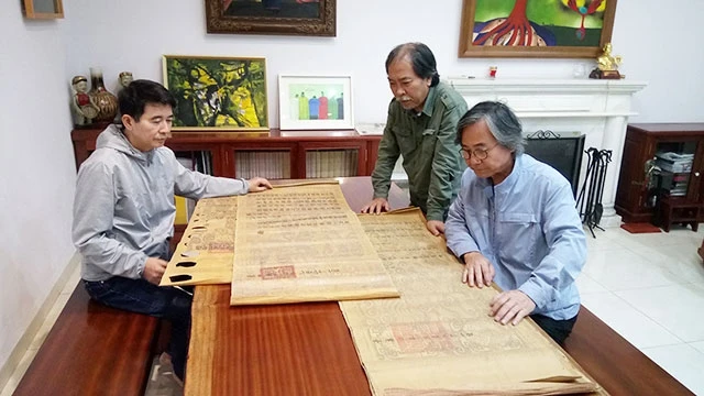 Từ trái qua: Ba thành viên nhóm Hà Đông - tác giả Trịnh Hữu Sỹ, nhà thơ Nguyễn Quang Thiều, đạo diễn Lương Tử Đức kiểm tra một số bản sắc phong.