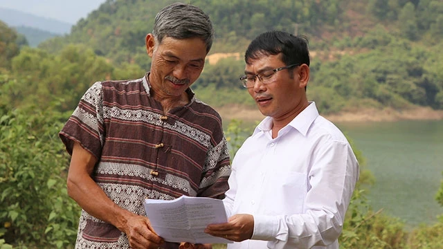 Ông Hà Khoa (trái) xem lại hồ sơ hoàn thiện thửa đất quyên góp chống dịch.