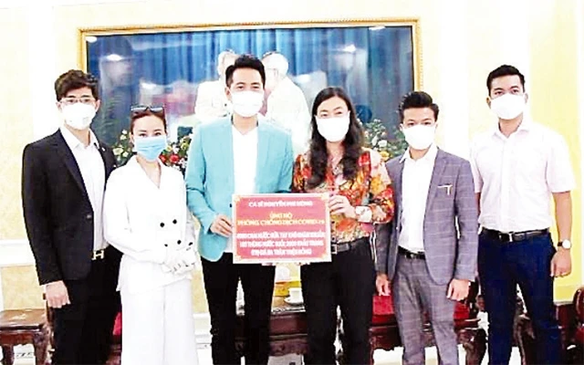 Ca sĩ Nguyễn Phi Hùng (thứ 3 từ trái sang) cùng đồng nghiệp ủng hộ nước diệt khuẩn và khẩu trang.