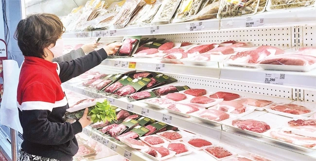 Người tiêu dùng lựa chọn thịt lợn tại siêu thị Vinmart Hà Nội. Ảnh: ĐĂNG ANH