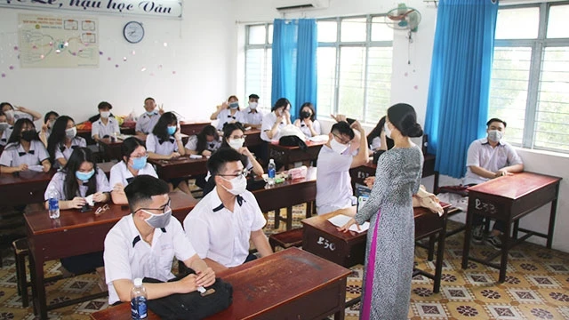 Học sinh Trường THPT Nguyễn Du nghe hướng dẫn về cách phòng, chống dịch trong ngày đầu quay trở lại trường.