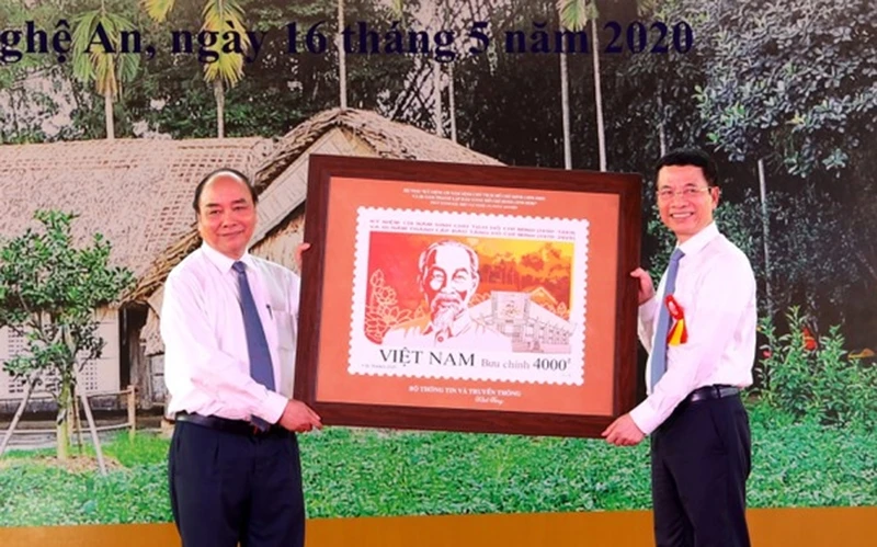 Thủ tướng Chính phủ Nguyễn Xuân Phúc nhận lưu niệm bộ tem kỷ niệm 130 năm ngày sinh Chủ tịch Hồ Chí Minh từ Bộ trưởng TT - TT Nguyễn Mạnh Hùng.