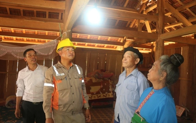  Công nhân Công ty Điện lực Sơn La hướng dẫn bà con xã Chiềng Bằng, huyện Mai Sơn sử dụng điện.