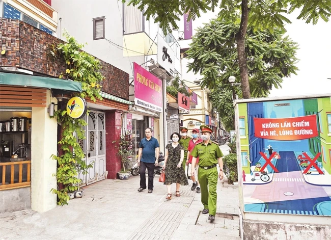 Cán bộ tổ dân phố 17 phường Khương Mai (quận Thanh Xuân) cùng cảnh sát khu vực nhắc nhở các cửa hàng kinh doanh bảo đảm trật tự đô thị.