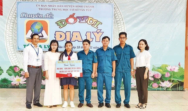Đại diện Chi bộ Quân sự thị trấn Tân Túc (huyện Bình Chánh) trao học bổng tặng học sinh nghèo hiếu học tại Trường THCS Tân Túc.