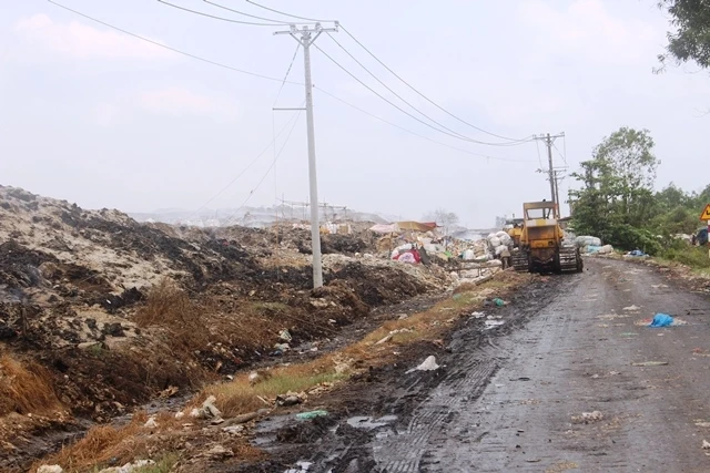 Các xe máy ủi rác lên cao tại bãi rác xã Tân Lập 1 (huyện Tân Phước).