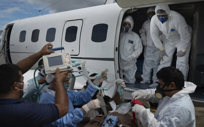 Các nhân viên y tế Brazil chuyển người bệnh Covid-19 lên máy bay để tới bệnh viện ở Manaus, ngày 19-5. (Ảnh: Reuters)