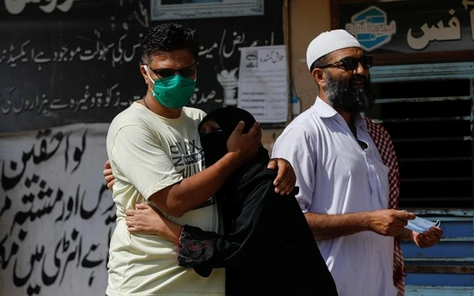 Người thân của các nạn nhân trong vụ tai nạn máy bay đứng bên ngoài nhà xác tại TP Karachi, ngày 23-5. (Ảnh: Reuters)