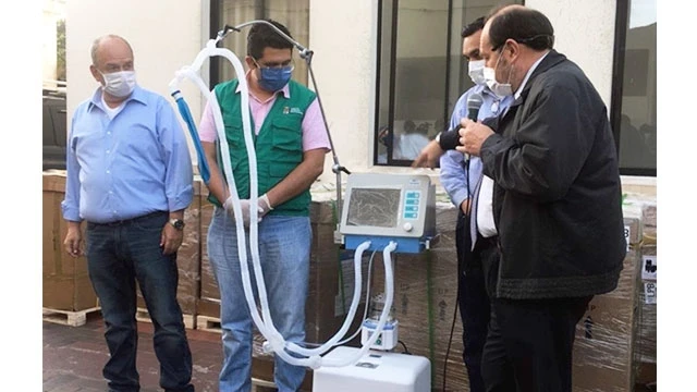 Ông Marcelo Navajas (phải) đang giới thiệu một máy trợ thở được nhập về bệnh viện.Ảnh: AFP