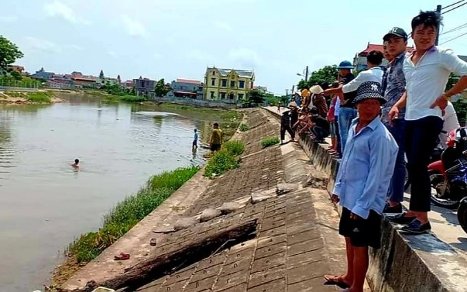 Người dân địa phương nỗ lực tìm kiếm cháu bé bị đuối nước dưới kênh Quần Liêu, thuộc xã Nghĩa Sơn, huyện Nghĩa Hưng (Nam Định). 